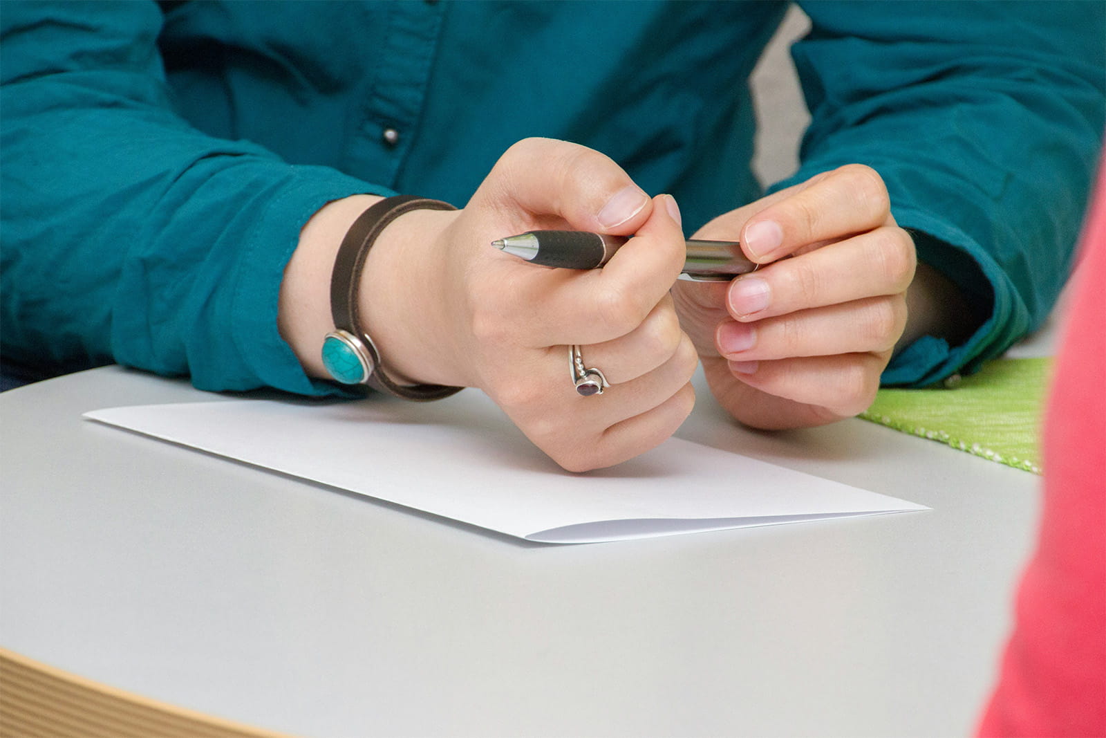 A person is seen writing on paper, capturing thoughts or ideas with a pen.