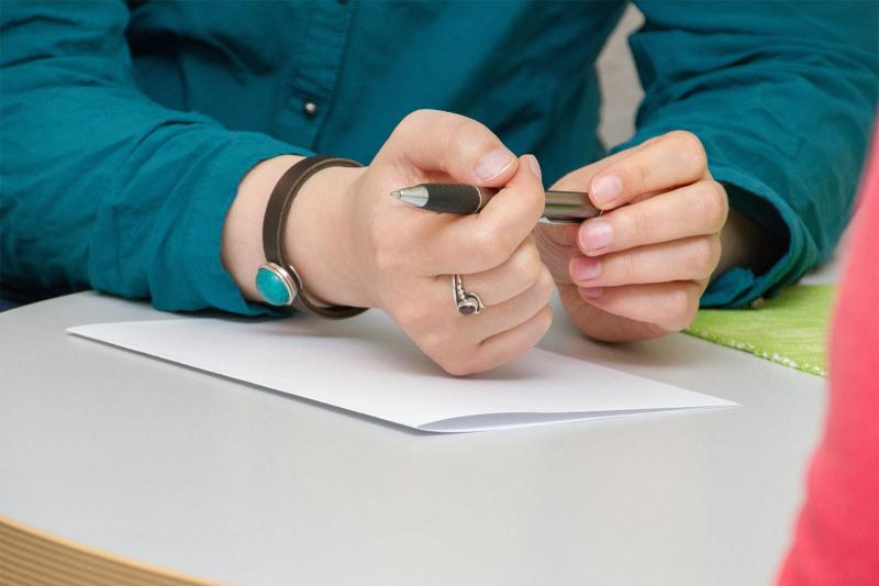 A person is seen writing on paper, capturing thoughts or ideas with a pen.